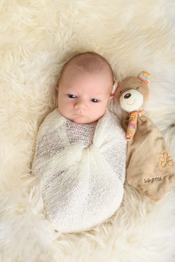 Baby kurz nach der Geburt, munter und aufgeweckt, beim Fotoshooting im Fotostudio